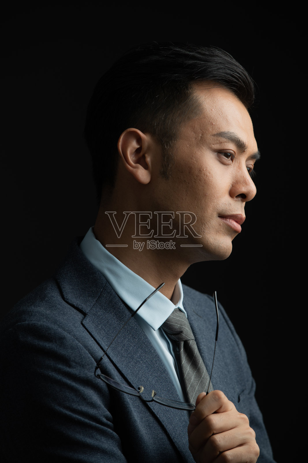 拿着眼镜思考的商务男士照片摄影图片