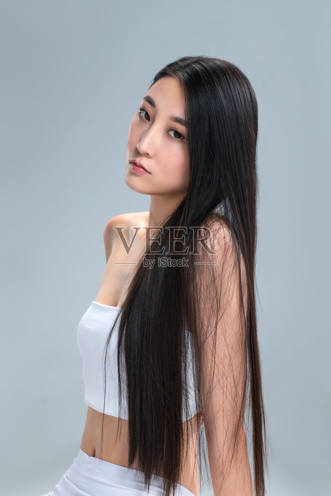 青年女人展示亮丽丝缎般的头发照片摄影图片