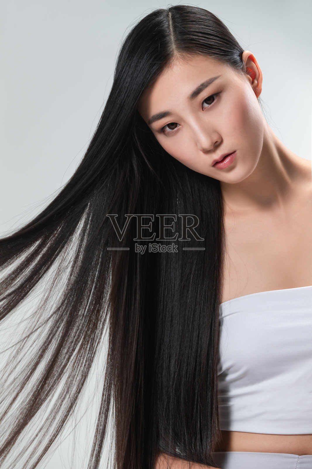 青年女人展示亮丽丝缎般的头发照片摄影图片