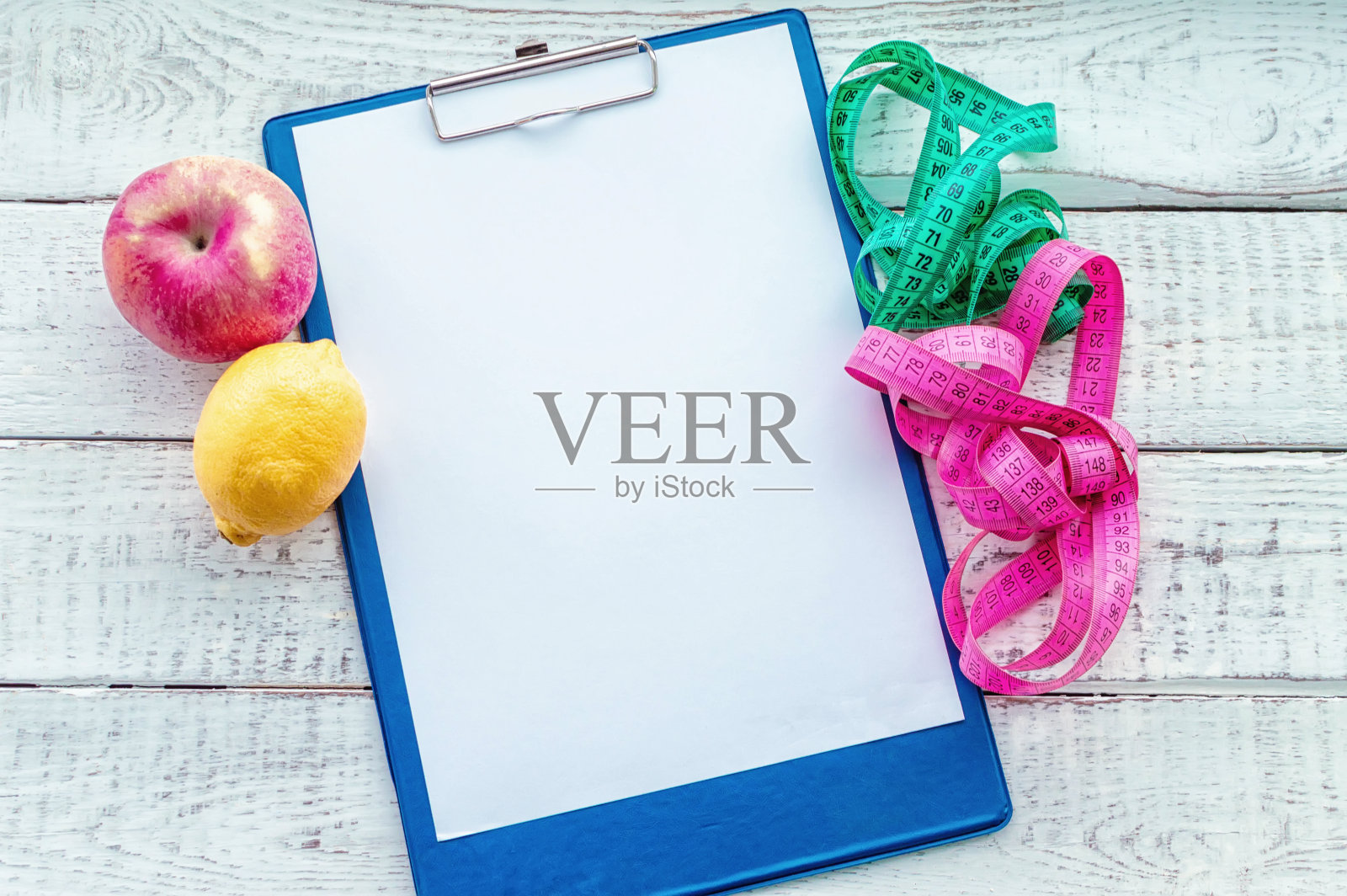 厘米长的磁带,苹果和柠檬,带空格的记事本。健康的概念,减肥,节食,群体燃烧,超重。极简主义,从上往下看。照片摄影图片