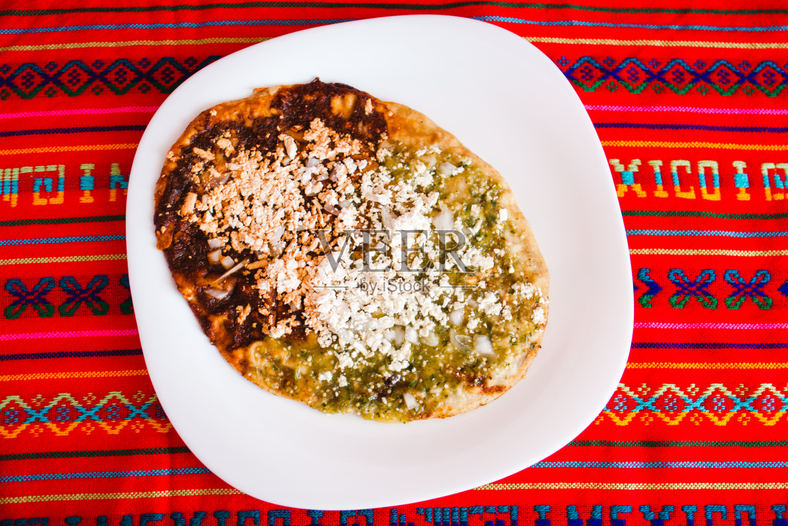 墨西哥菜,配碎奶酪和绿色莎莎酱,墨西哥风味的辛辣食物照片摄影图片