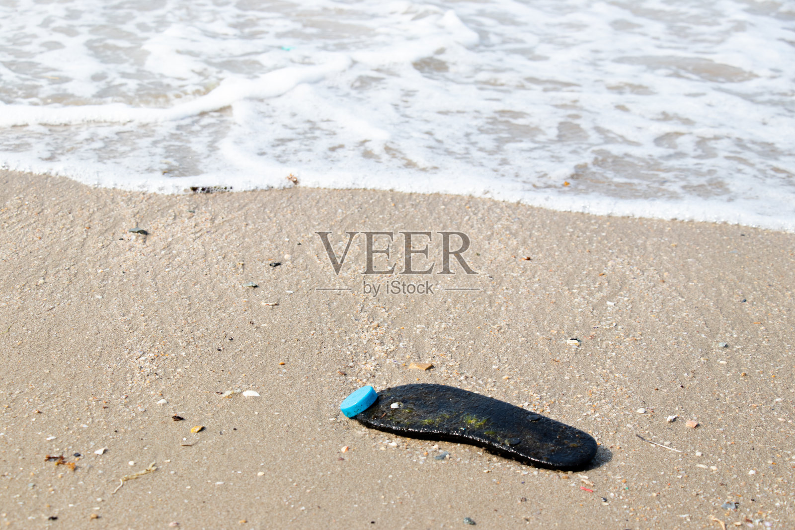 海滩背景的橡胶垃圾(海洋污染和污染的概念)照片摄影图片