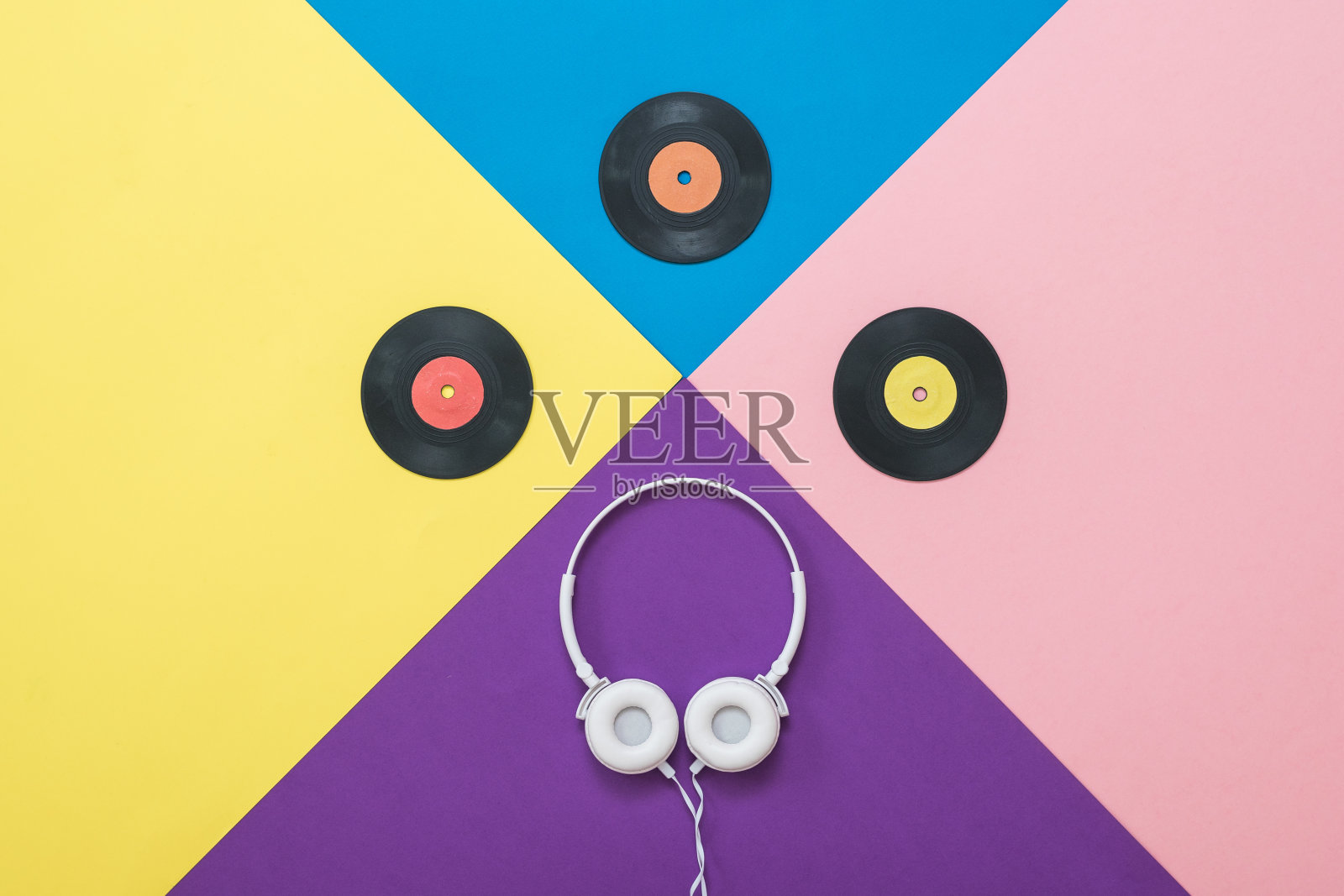 白色耳机与电线和vinyl disc在一个抽象的背景。照片摄影图片