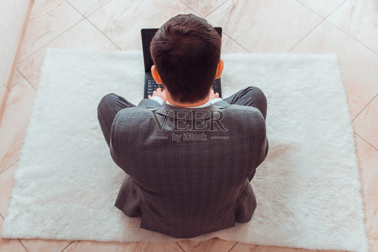 一个穿着西装在家里用笔记本电脑工作的人照片摄影图片