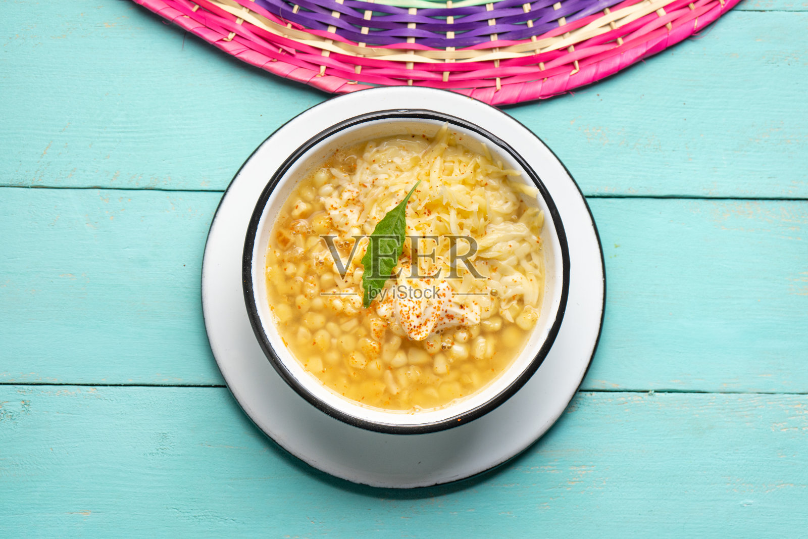 墨西哥玉米粒煮,也称为esquites与奶酪和蛋黄酱在绿松石背景照片摄影图片