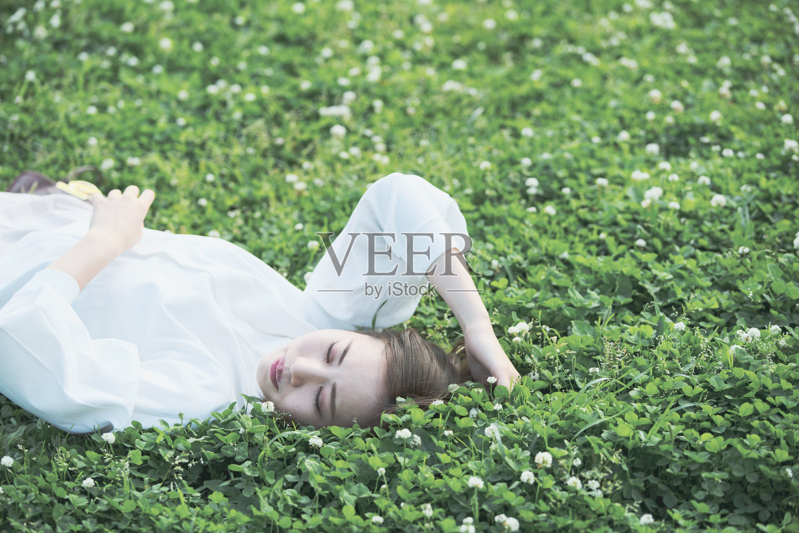 草地上的亚洲年轻女子照片摄影图片