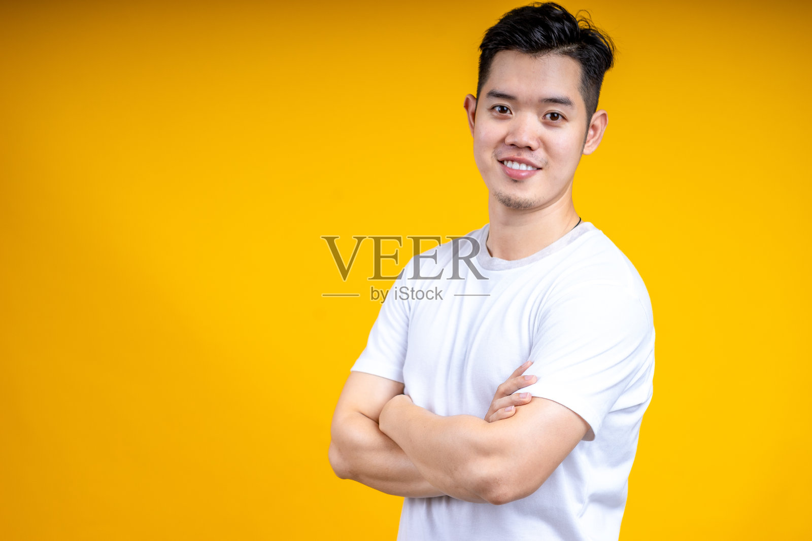 年轻的亚洲人穿着张贴隔离黄色背景。幸福,模型。照片摄影图片