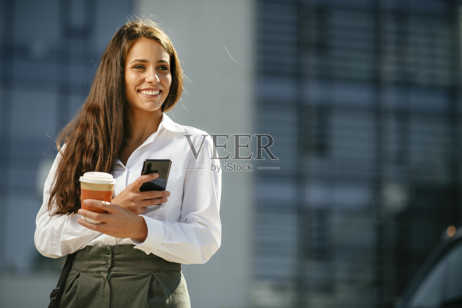 年轻的女商人喝咖啡,在户外打电话。照片摄影图片