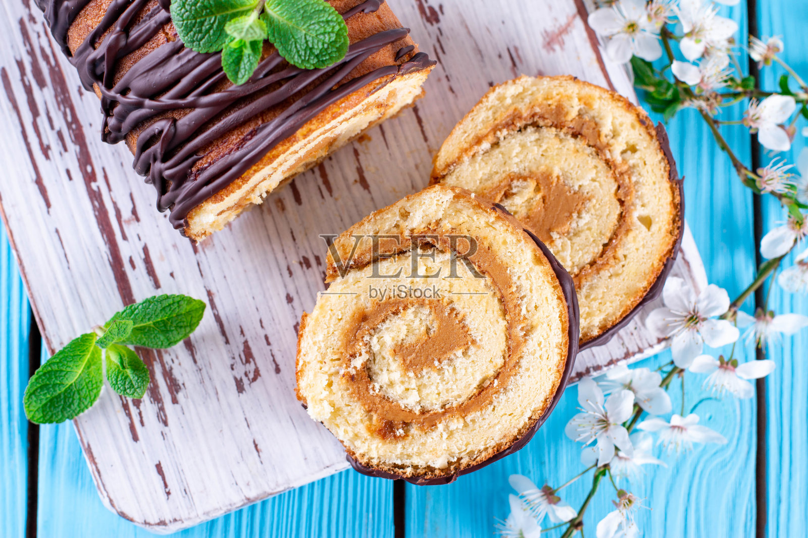 海绵蛋糕卷在蓝色的木制背景上照片摄影图片