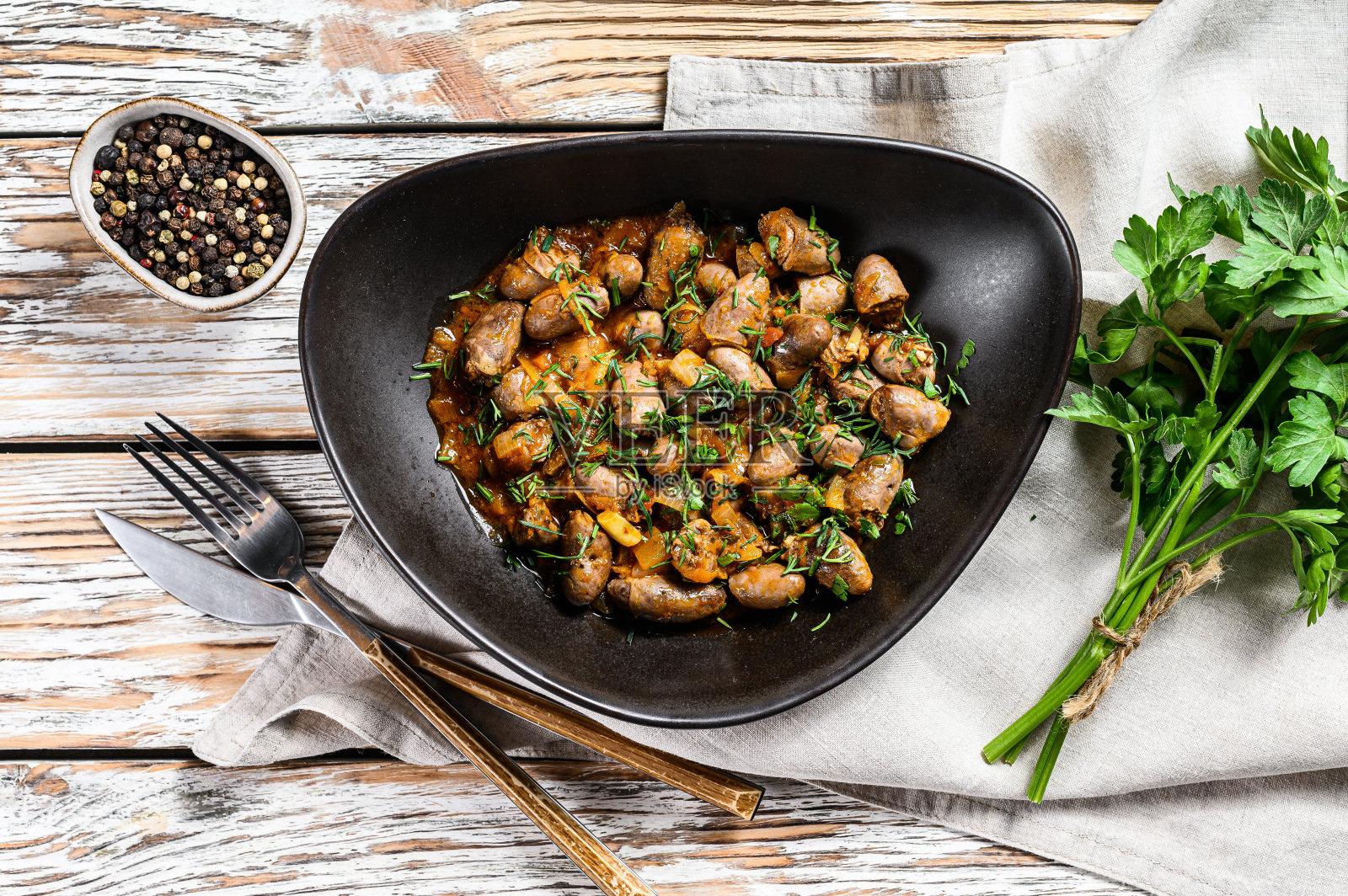 炖鸡肝心一盘。白色木制背景。俯视图照片摄影图片