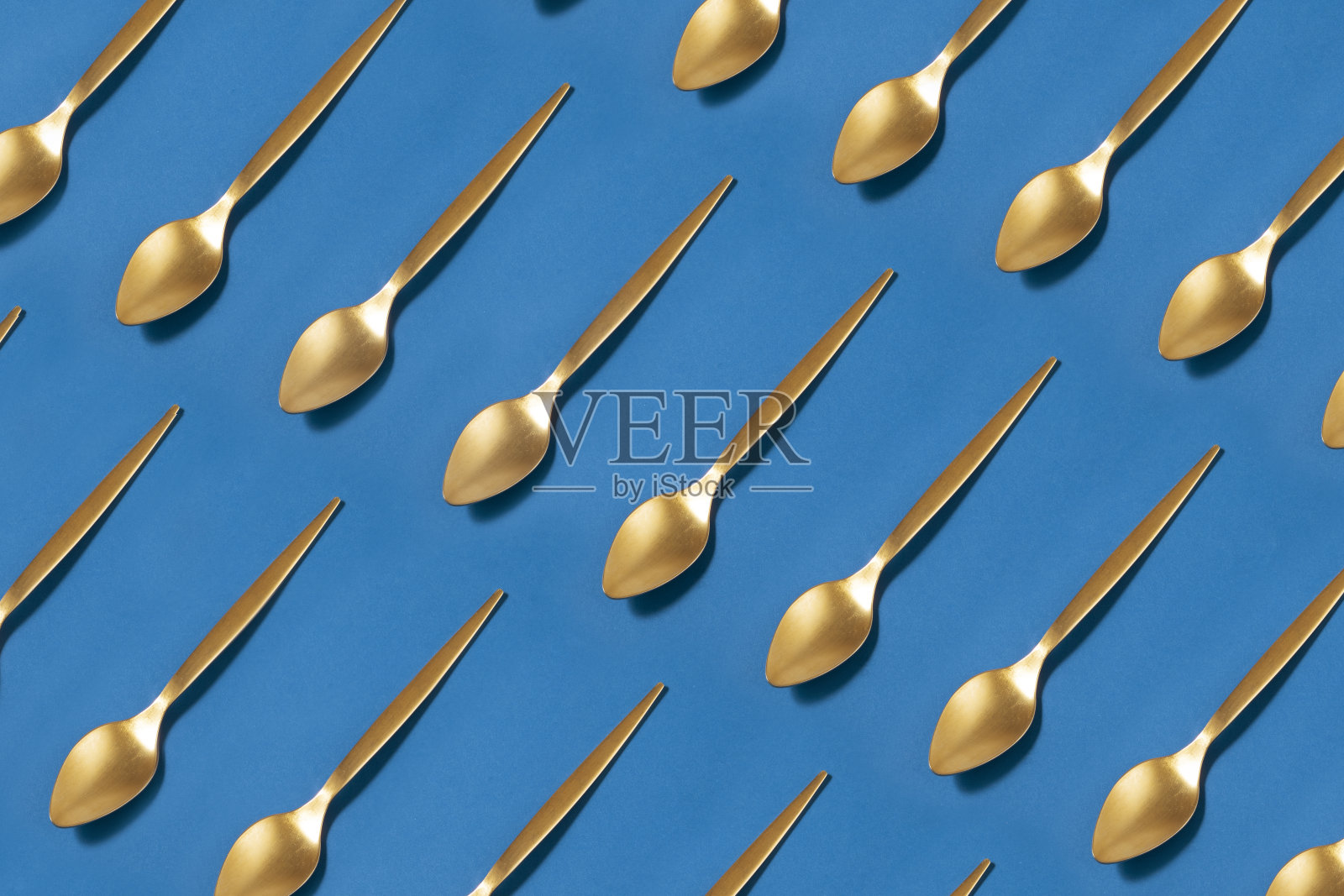 蓝色背景上的茶匙图案照片摄影图片