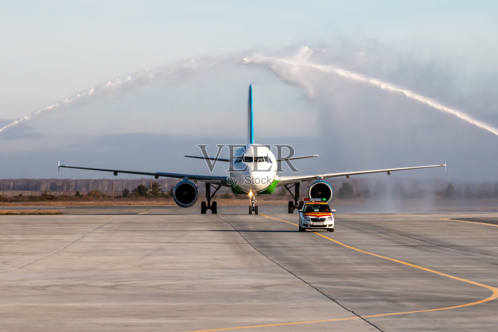 机场向首次访问的客机敬礼。飞机在“随车”后面移动照片摄影图片