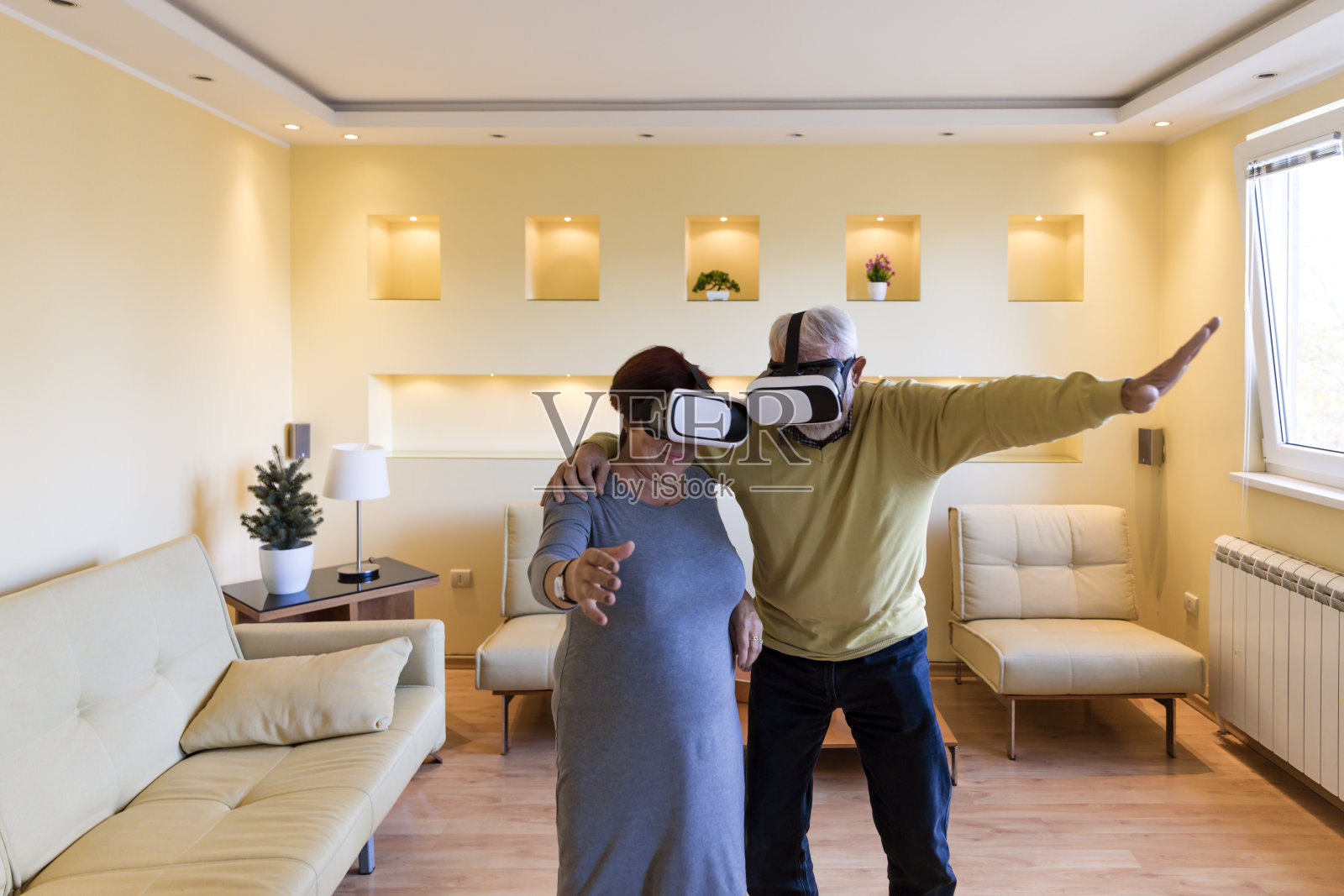 兴奋的老年夫妇正在体验虚拟现实模拟器与VR眼镜游戏。照片摄影图片