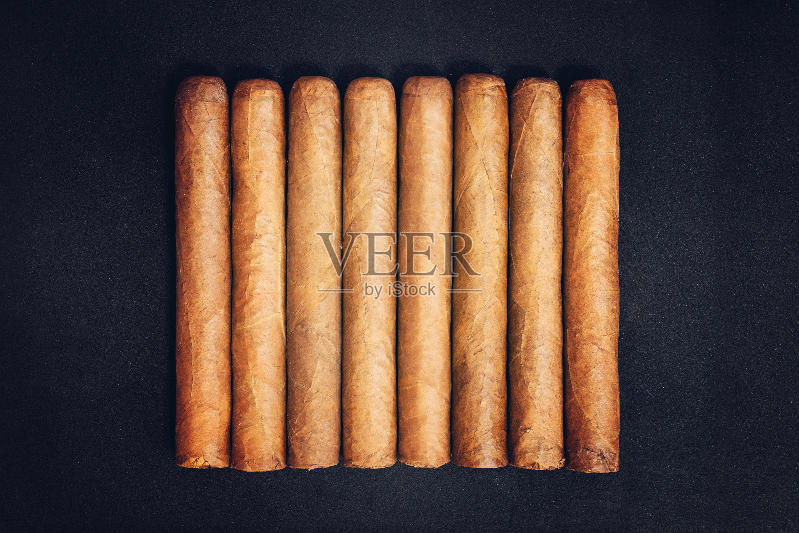 真正昂贵的古巴雪茄。黑暗中,黑桌子上放着哈瓦那雪茄照片摄影图片