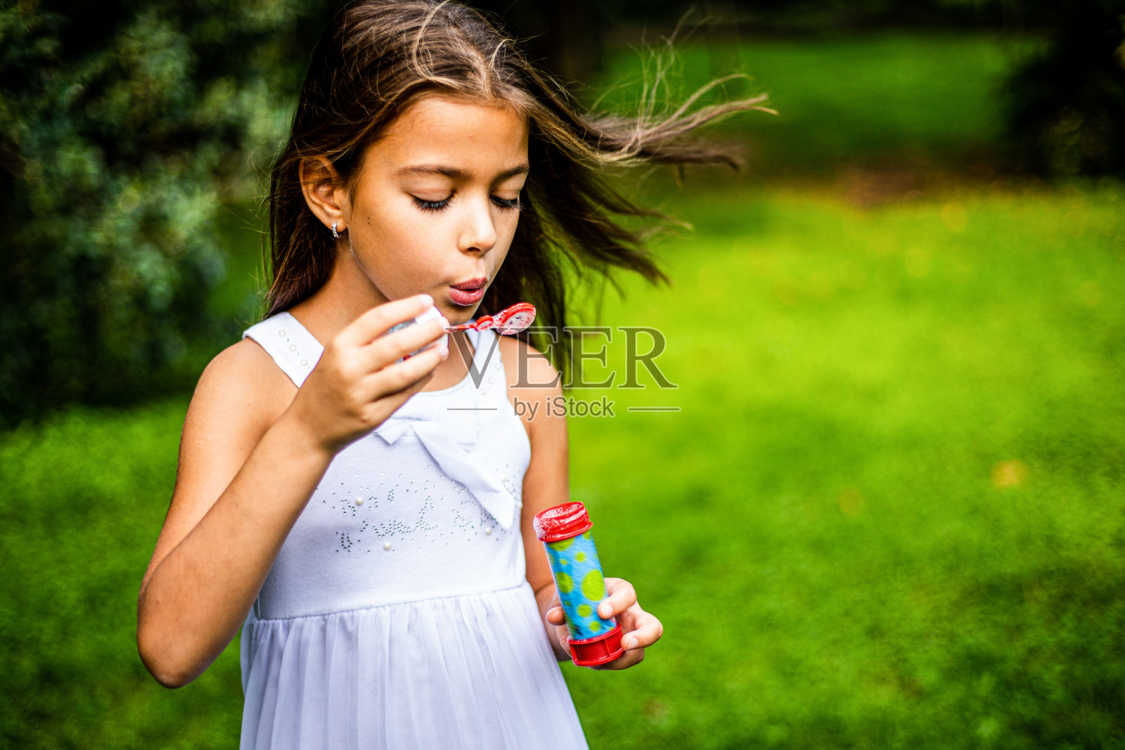 可爱的女孩在大自然中玩肥皂泡照片摄影图片