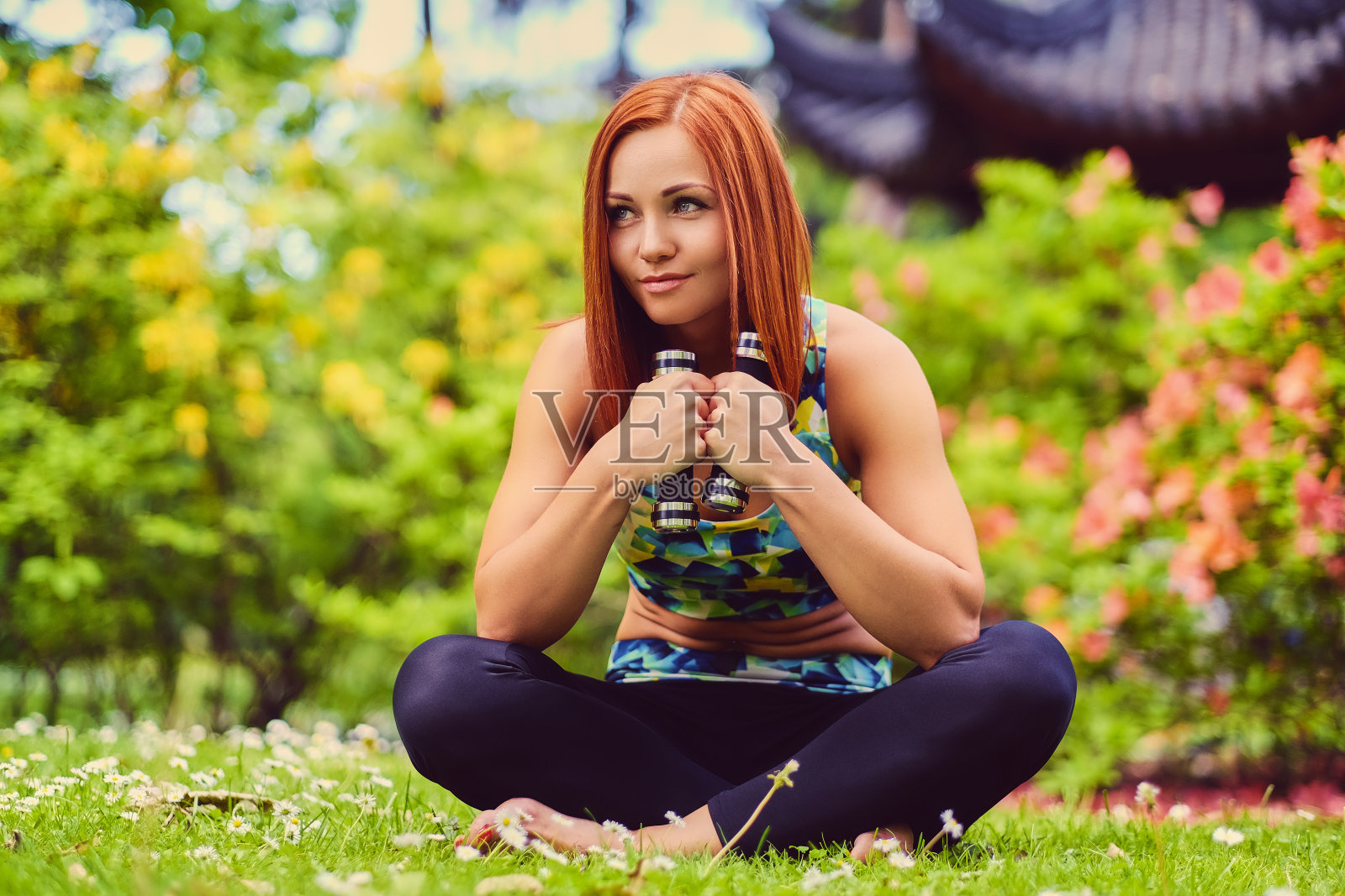 运动红发女性放松在户外夏季公园。照片摄影图片