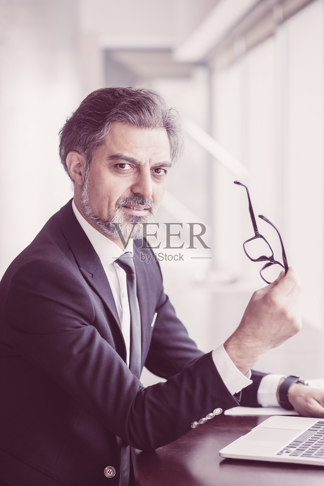 坐在办公桌前的严肃商业领袖照片摄影图片