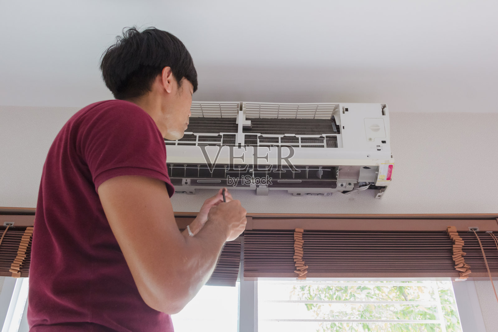 男人打扫家里的空调照片摄影图片