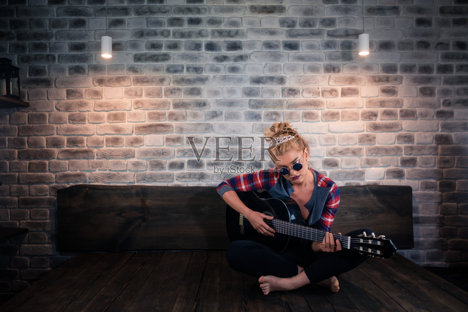 漂亮的金发女孩穿着休闲衣服用吉他演奏音乐照片摄影图片