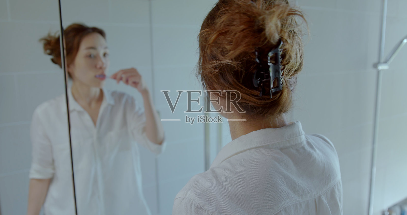 年轻女子在浴室里准备。照片摄影图片