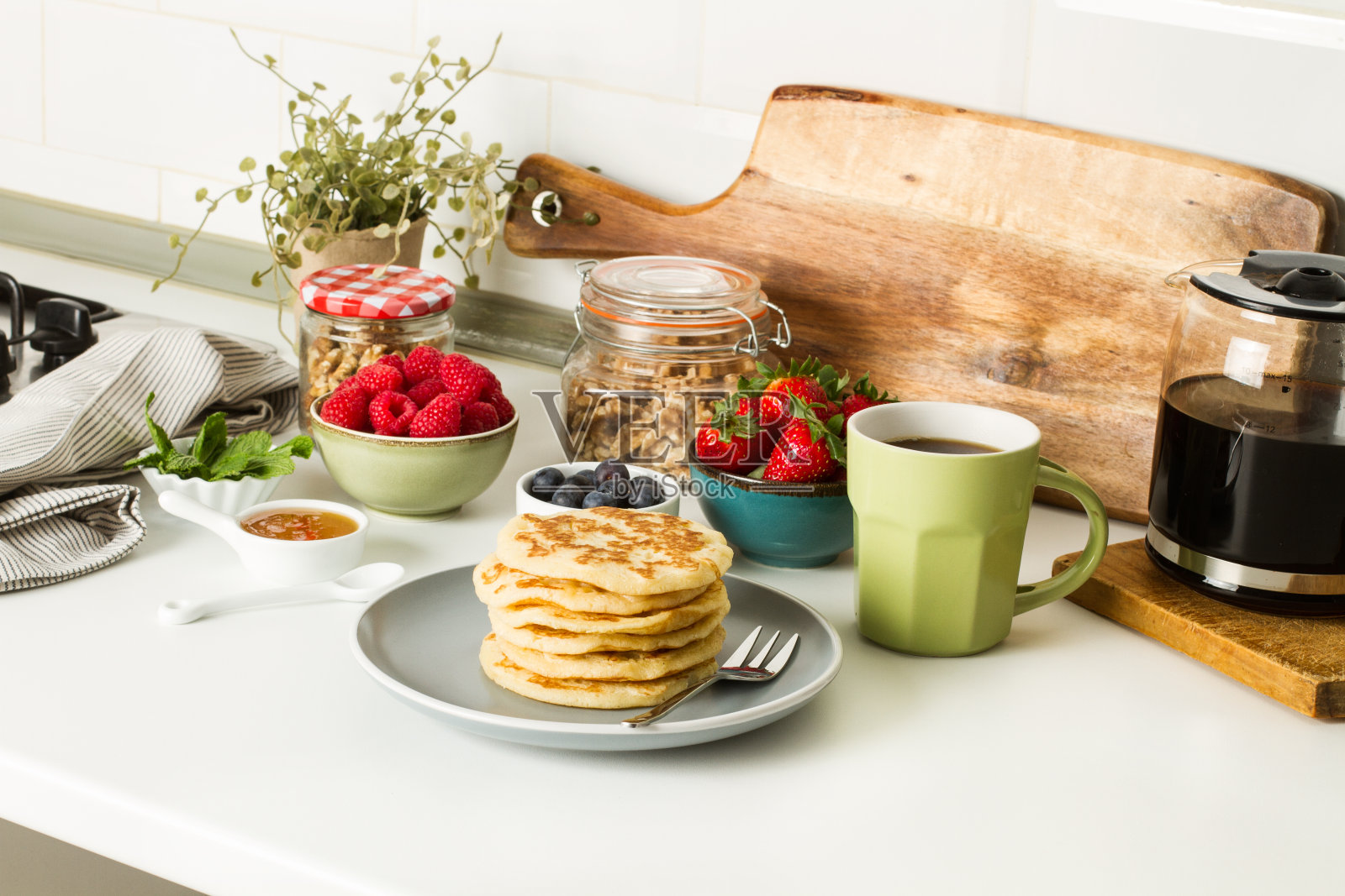 灰色盘子里放着带浆果和蜂蜜的煎饼,再配上一杯咖啡照片摄影图片