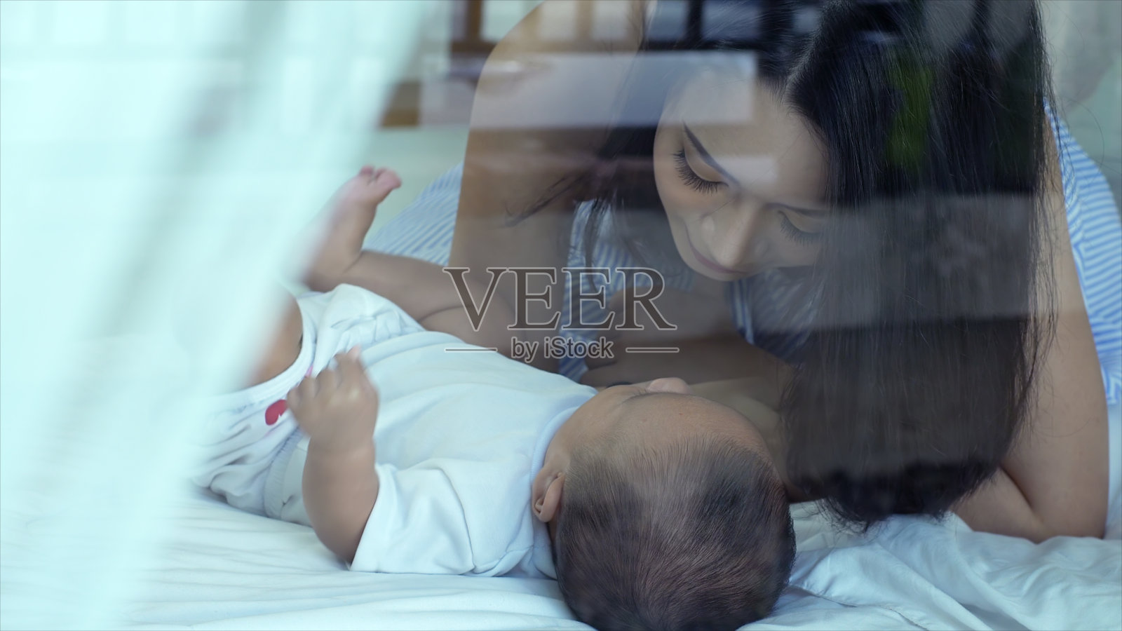 年轻美丽的亚洲母亲关心和玩她的孩子照片摄影图片