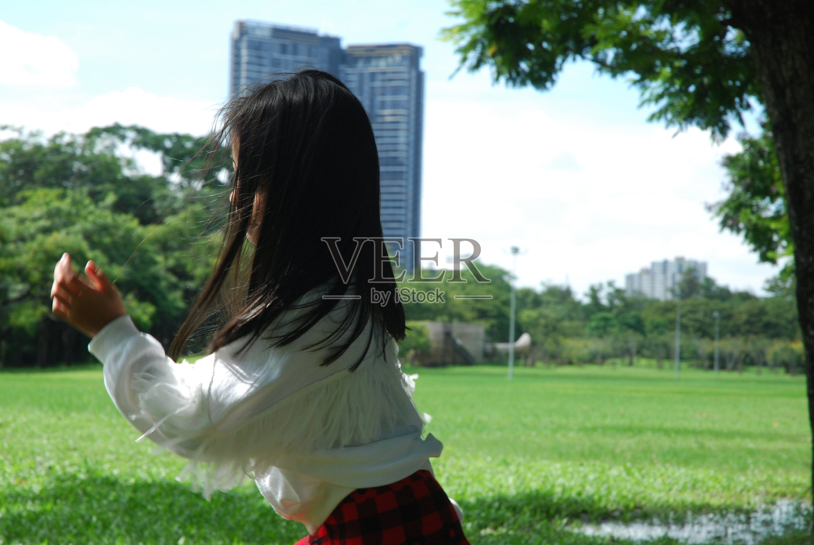 美丽的亚洲女孩快乐的玩和写作在公共公园在假期的周末。照片摄影图片