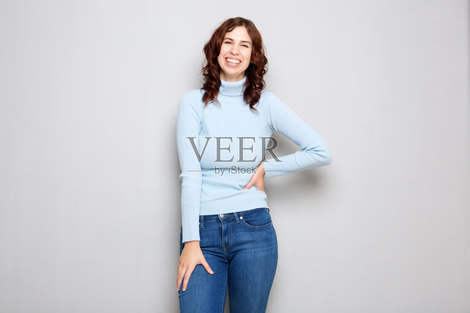 年轻女子在灰色背景下笑着照片摄影图片