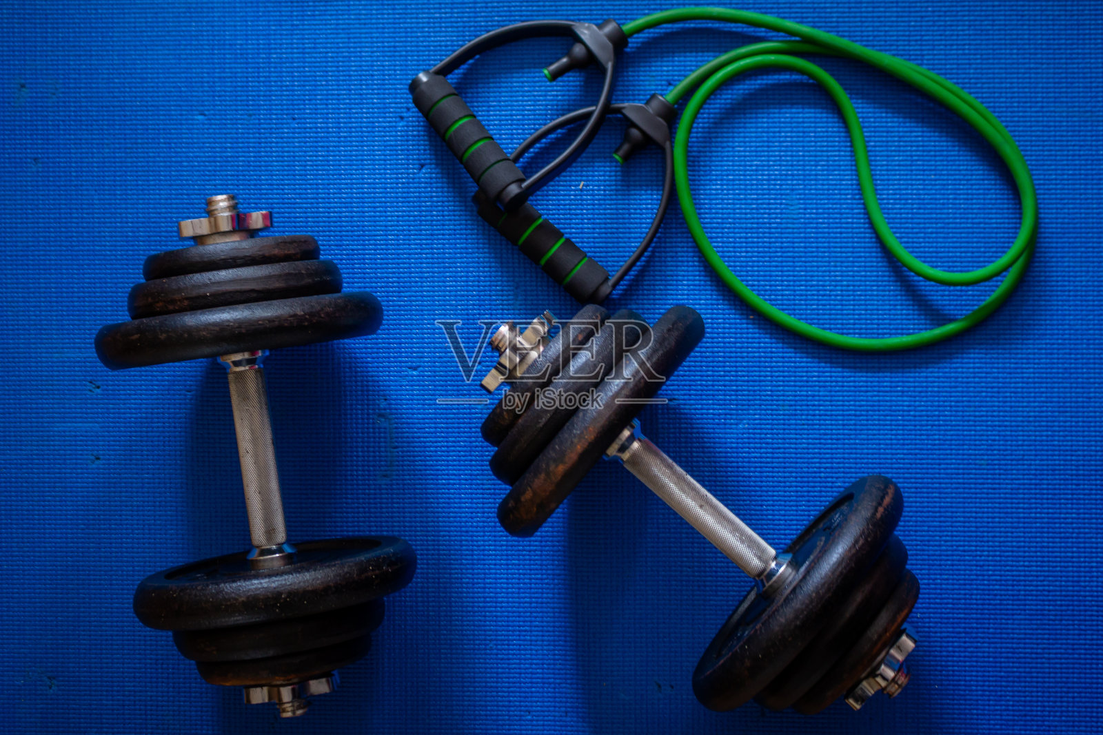 一对金属哑铃和一条绿色运动带照片摄影图片