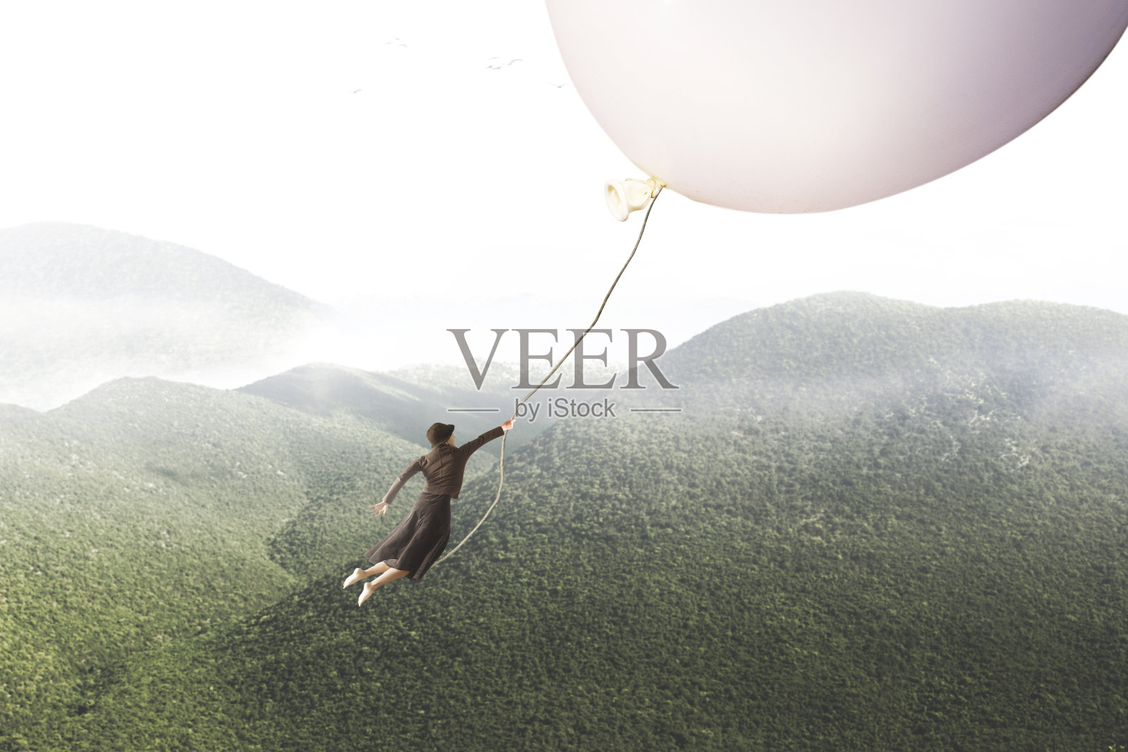 一个女人被一个巨大的气球带着的冒险旅程照片摄影图片