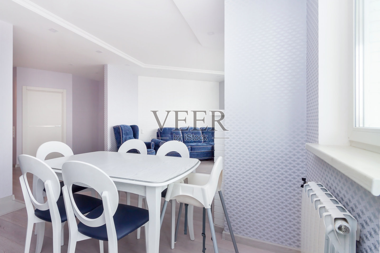 美丽的白色用餐区,配有6张大型餐桌和椅子,配有窗户和蓝色家具照片摄影图片