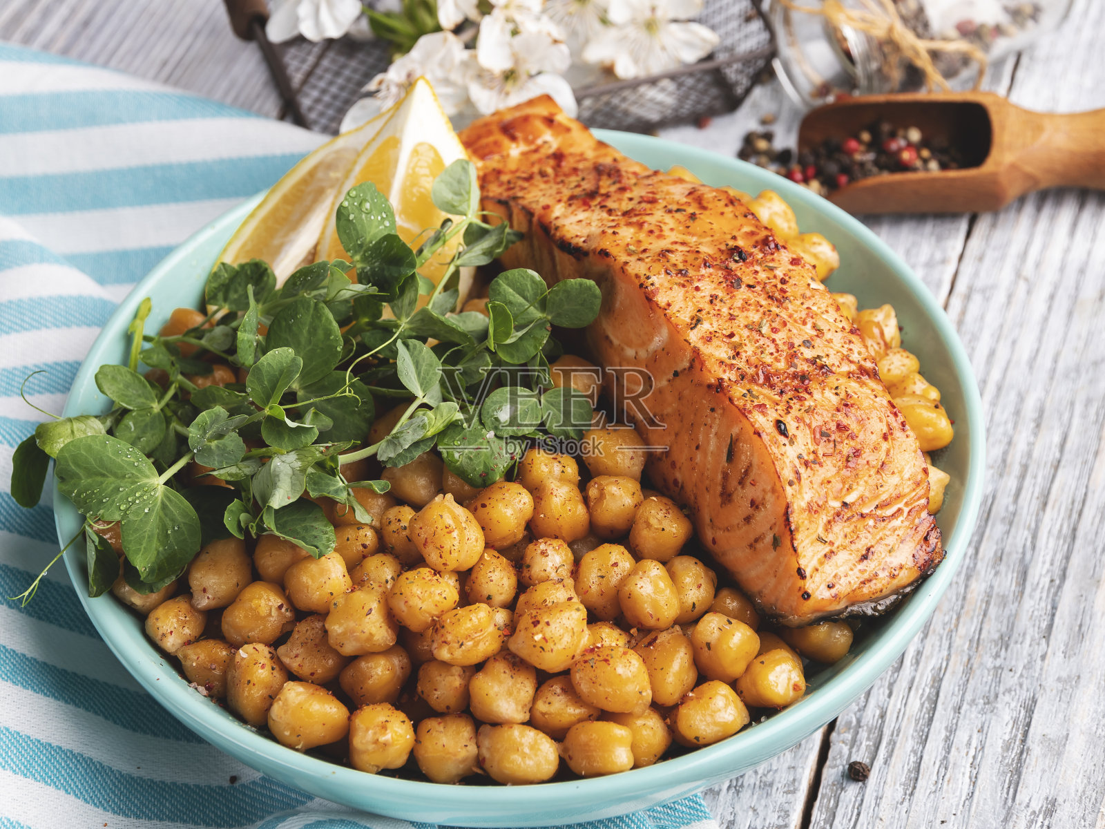 烤三文鱼片配鹰嘴豆、柠檬和豌豆芽是健康的食物照片摄影图片