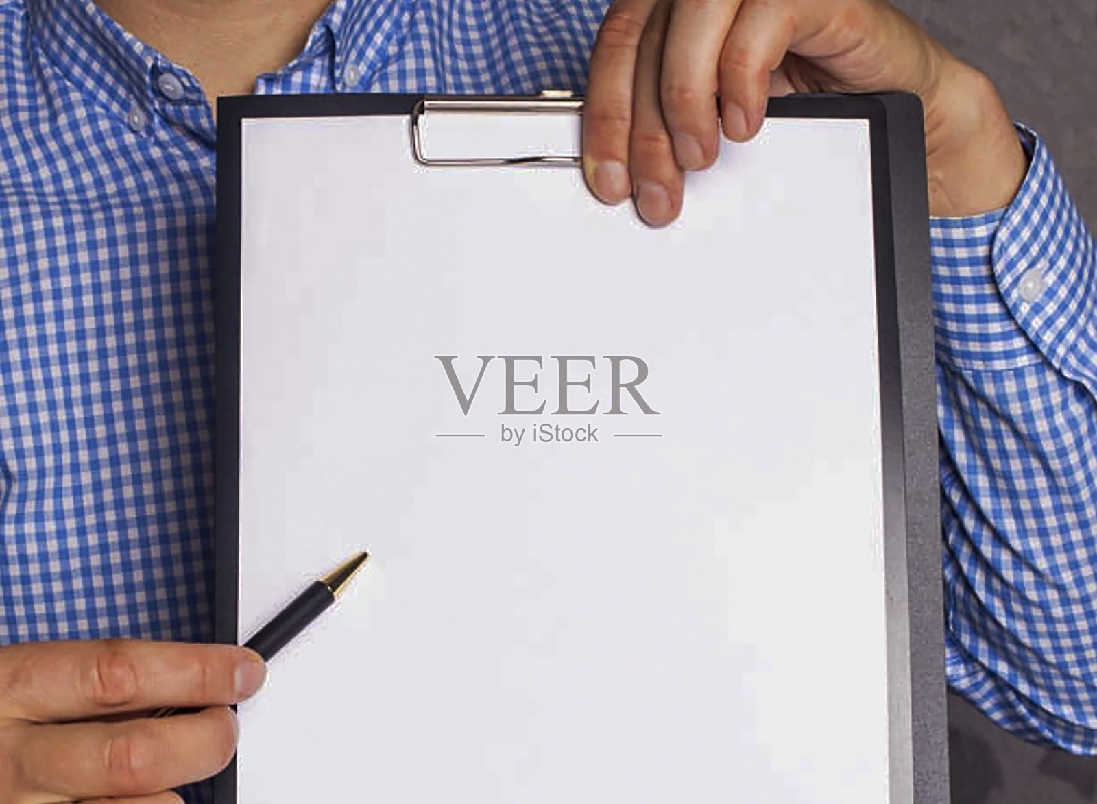 一个男人指着他手里拿着的一张白纸照片摄影图片