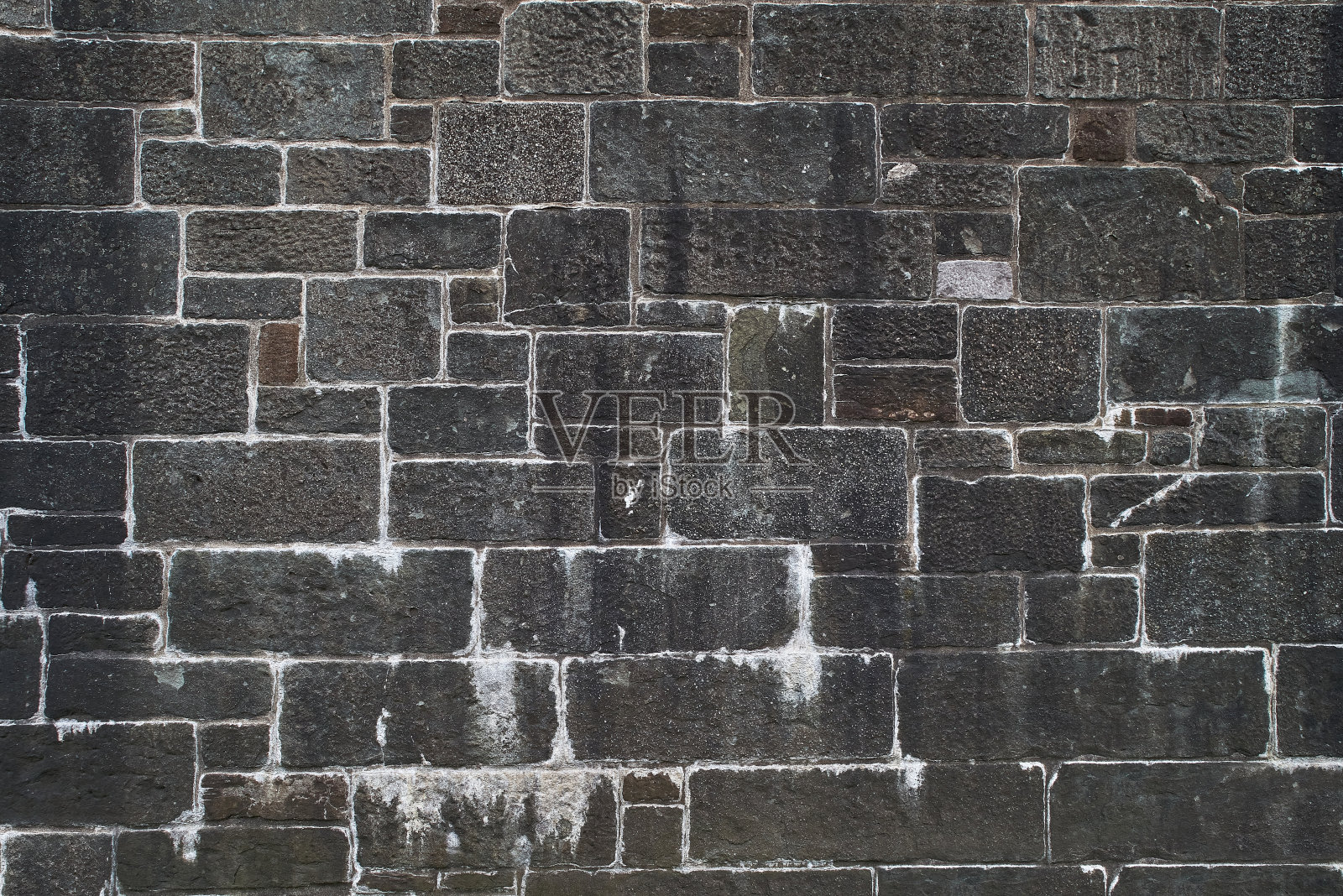 石墙的纹理。古城堡的石墙背景。用野生石头砌成的墙。自然背景照片摄影图片