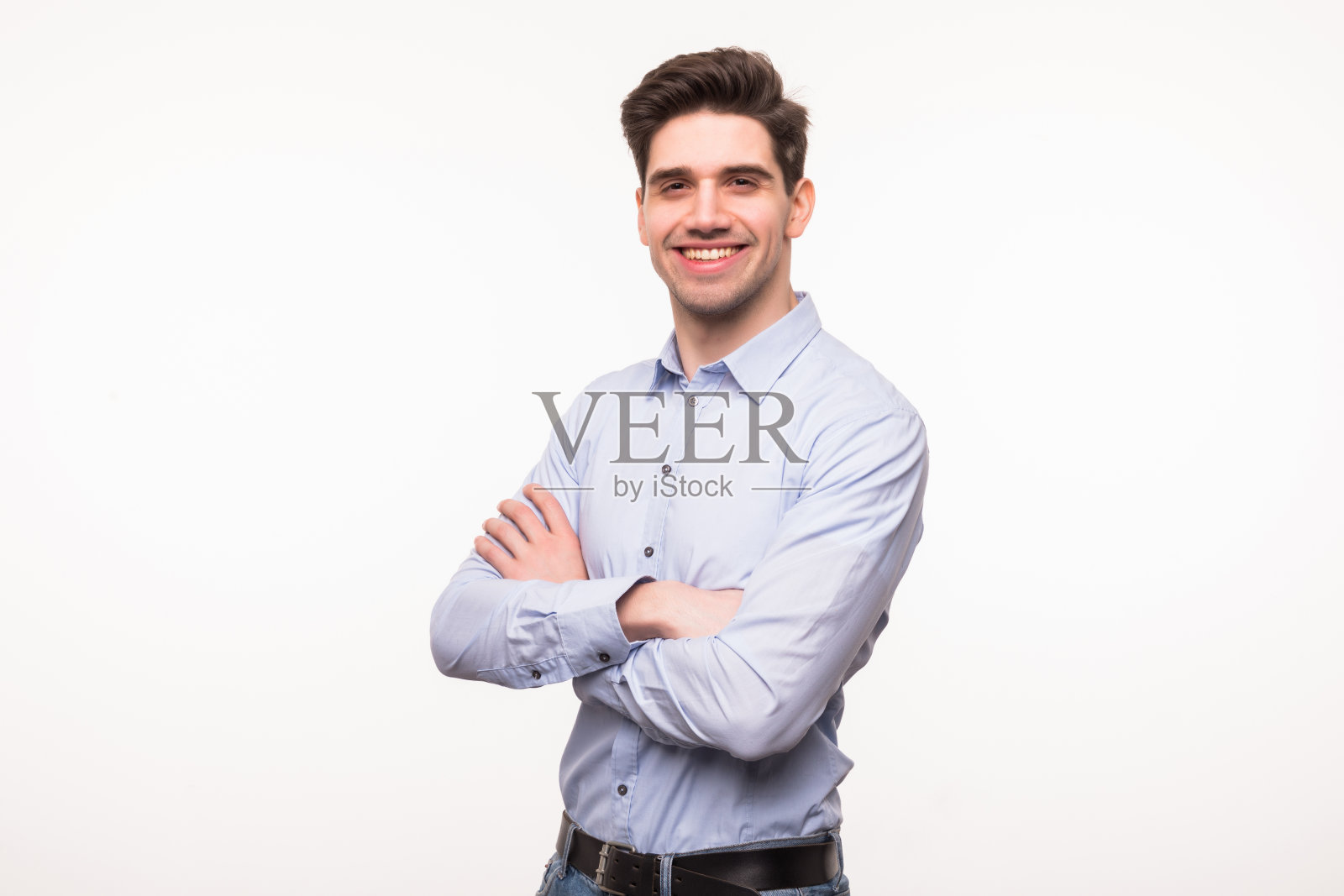 一个年轻男子的肖像微笑与双手交叉在一个白色的背景照片摄影图片