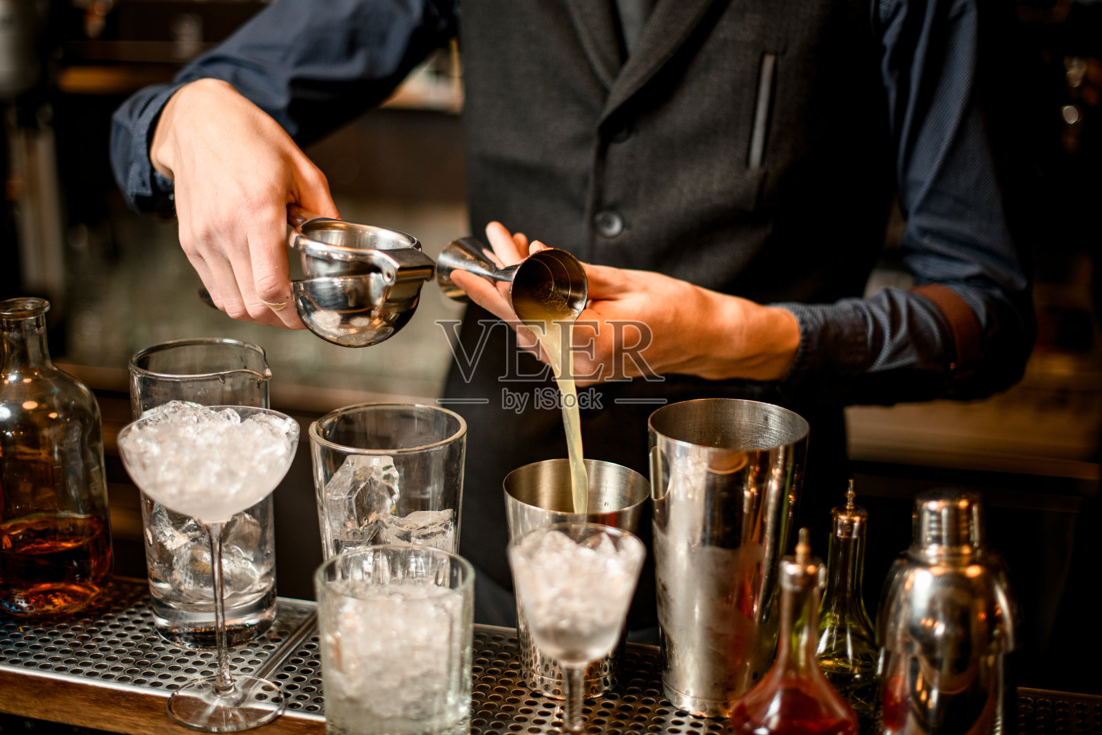 调酒师将榨好的果汁从烧杯倒入摇酒器照片摄影图片