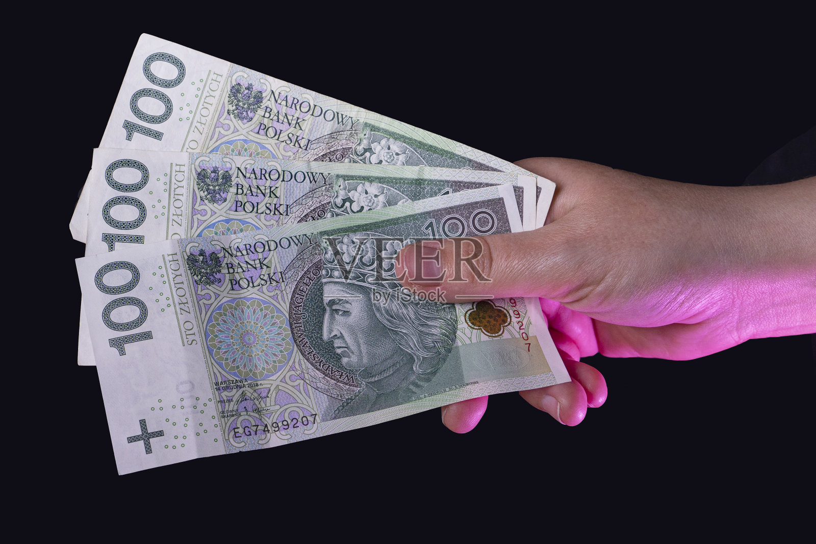 那只手拿着波兰钞票。波兰的货币。照片摄影图片