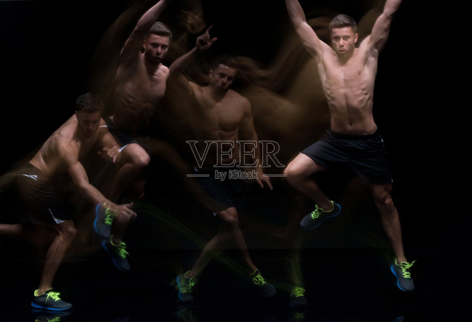 身穿运动服的白人年轻男性运动员在黑色背景前跳跃照片摄影图片