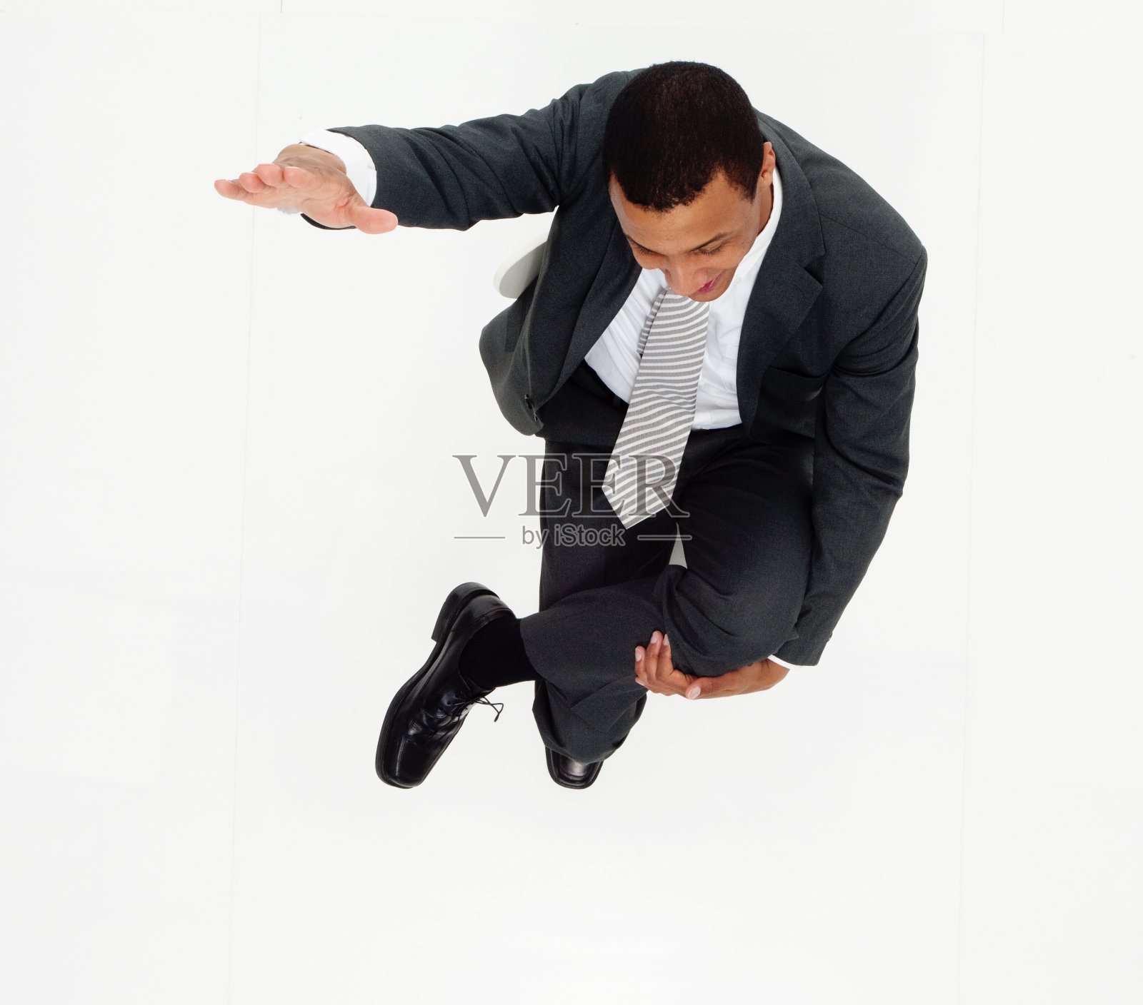 非裔美籍年轻男性商务人士坐在白色背景下穿着商务装照片摄影图片