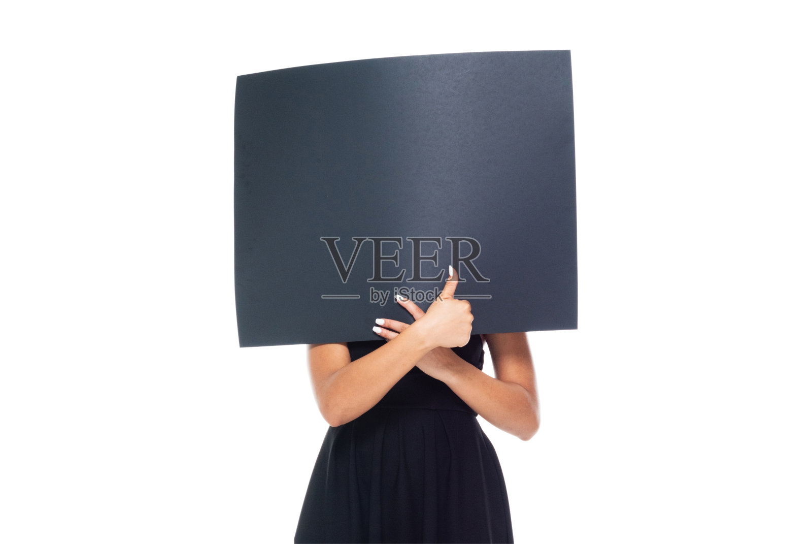 白色背景前的年轻女性穿着连衣裙,举着牌子照片摄影图片