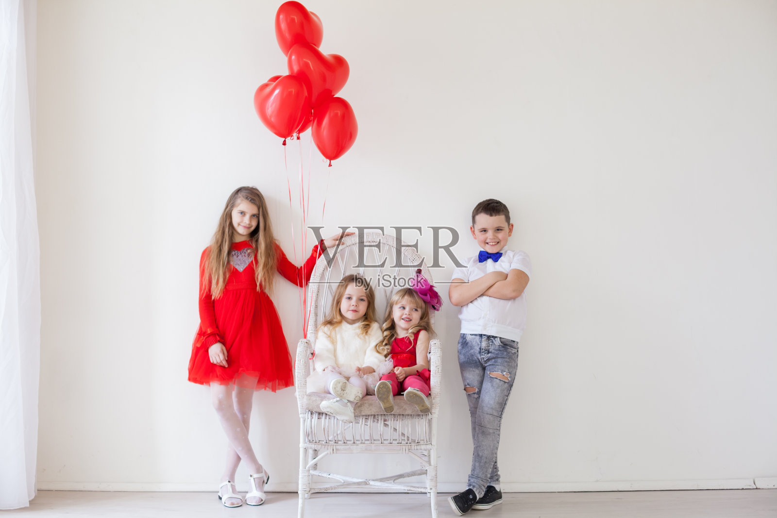 孩子们在节日里拿着红色的心形气球照片摄影图片
