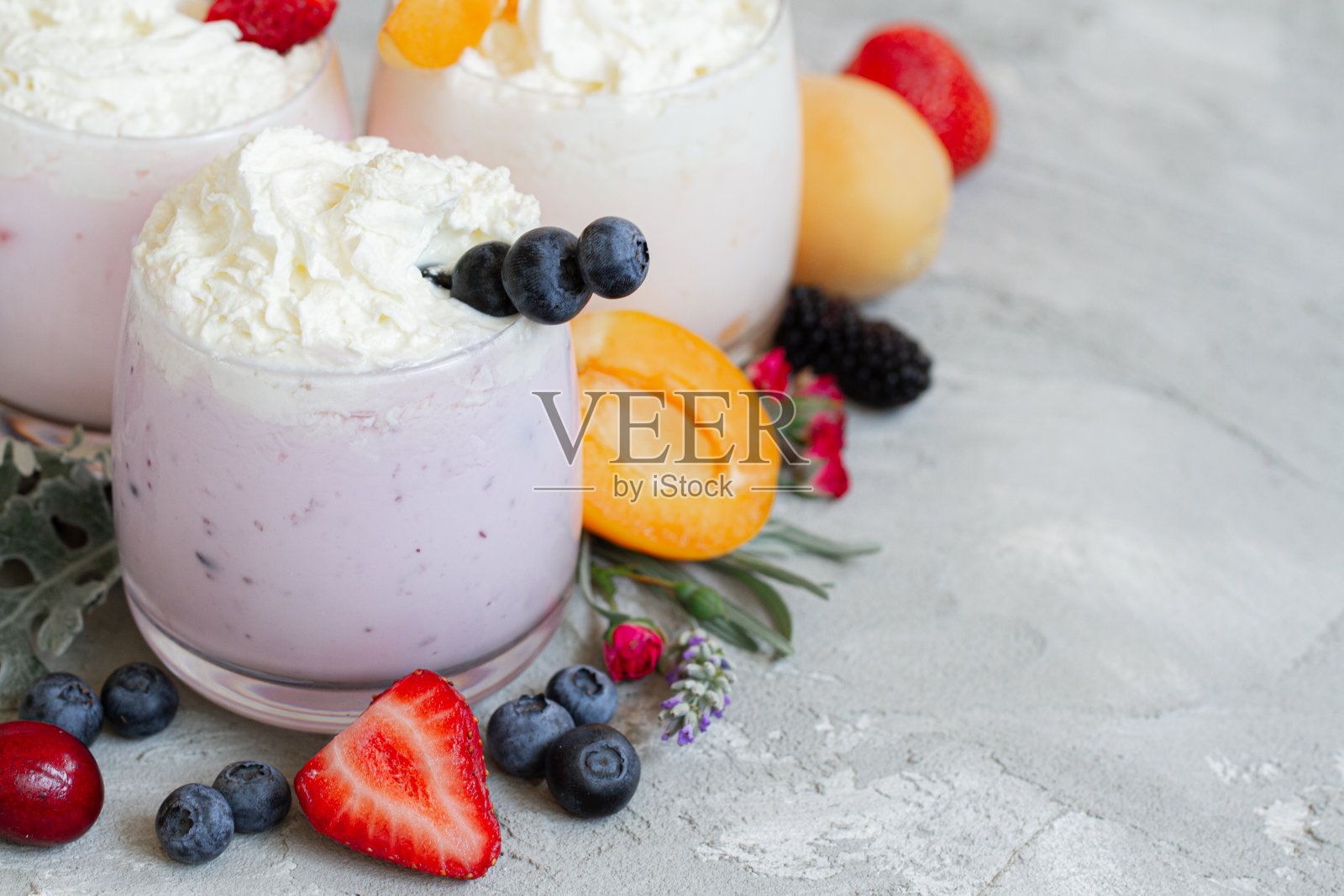 草莓,蓝莓冰沙在浅的背景。健康和减肥的概念。新鲜浆果奶昔。健康的早餐。含配料的水果奶昔。照片摄影图片