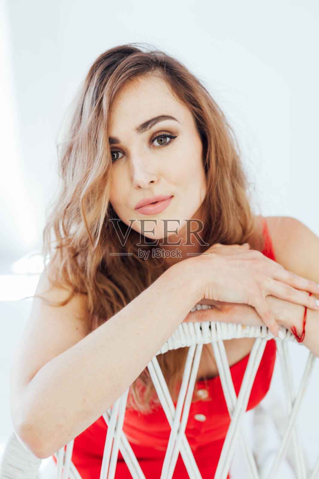 一个穿着红裙子在白色办公室里的漂亮时尚女人的肖像照片摄影图片