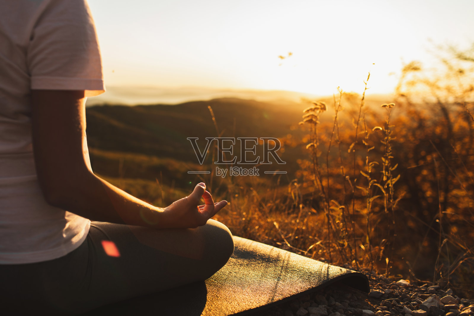女人的手在莲花的位置特写。禅修。健康的生活方式和瑜伽理念。温暖的阳光和山景背景。空的地方。照片摄影图片