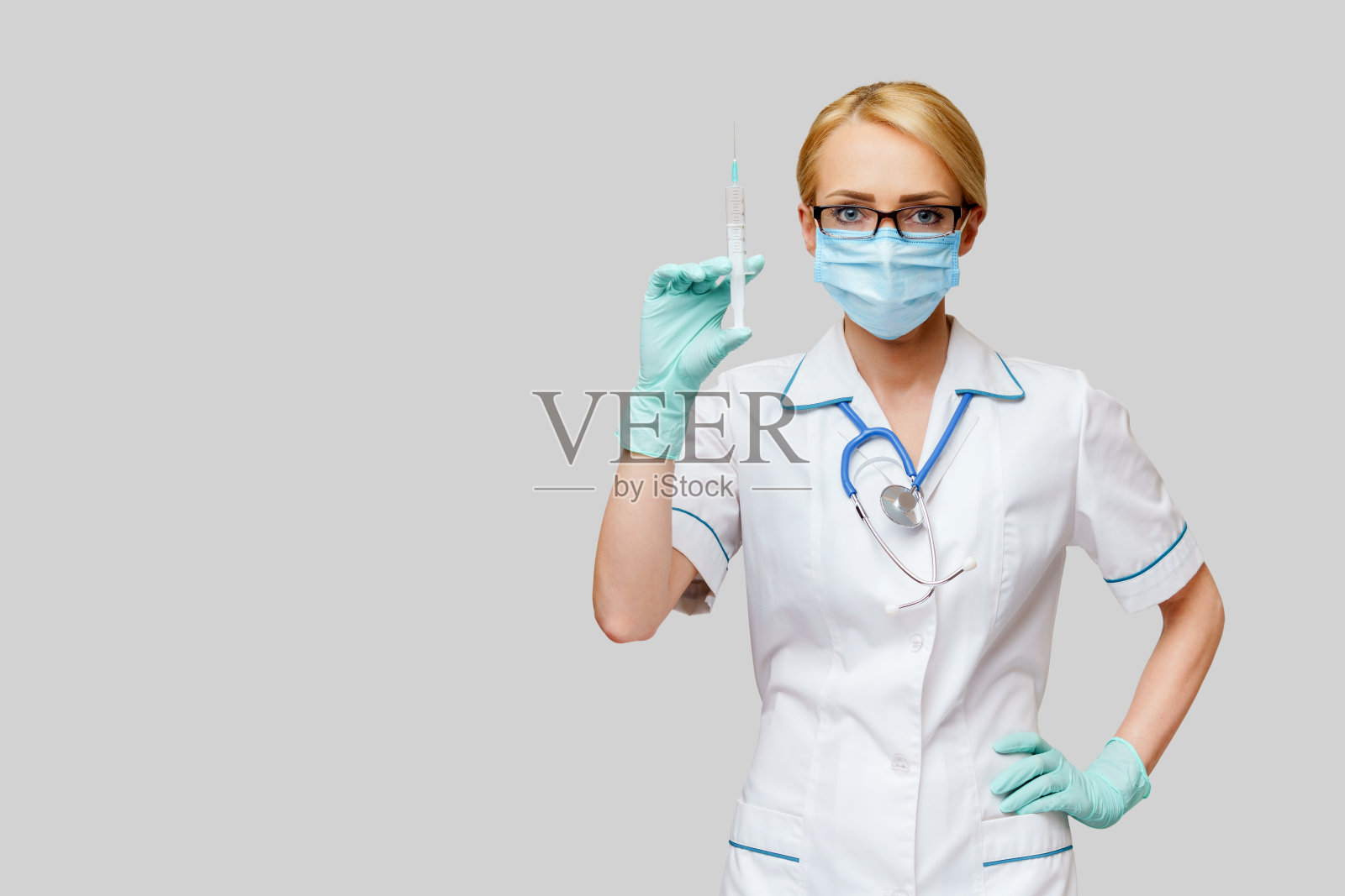 医生护士妇女戴防护口罩和手套拿注射器照片摄影图片