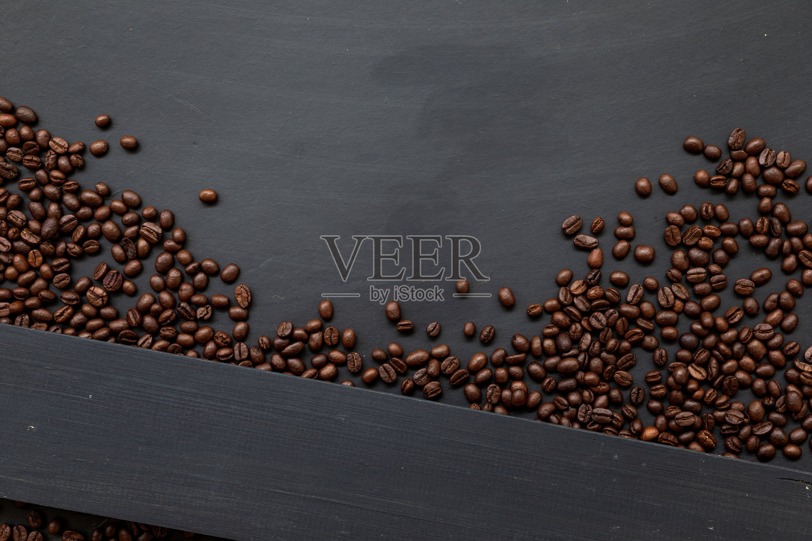 黑色木地板背景上的咖啡豆。前视图。空间的文本照片摄影图片