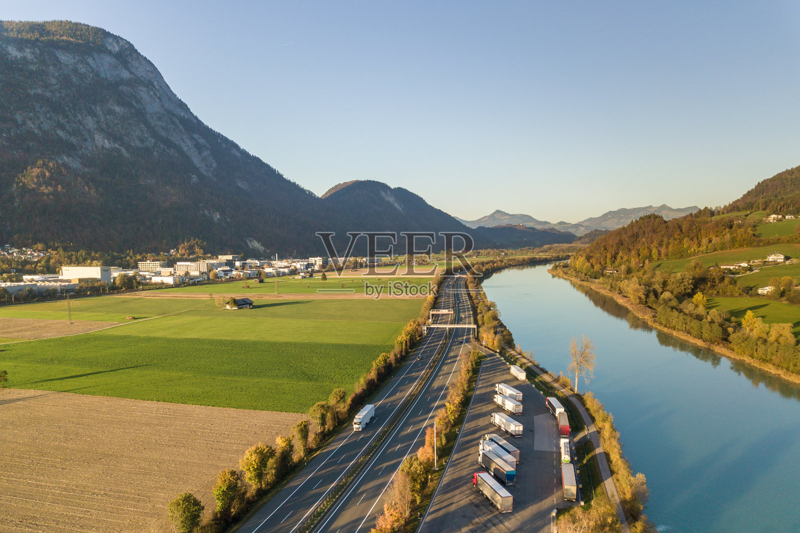 高速公路州际公路鸟瞰图与快速移动的交通附近的大河在阿尔卑斯山脉照片摄影图片