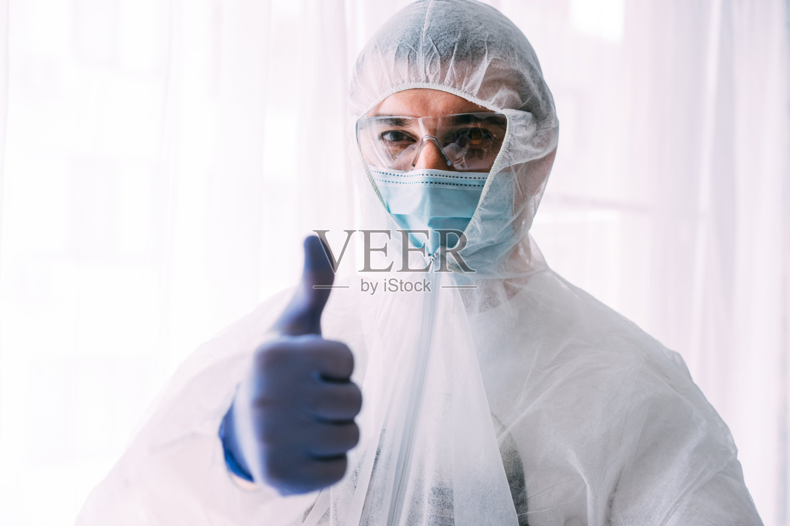 男医生或科学家穿着防护服,戴着面罩照片摄影图片