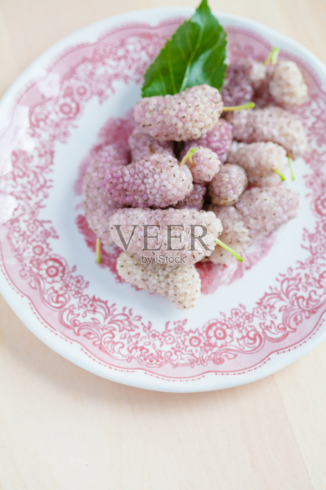 白色桑椹在一个粉红色的盘子里照片摄影图片