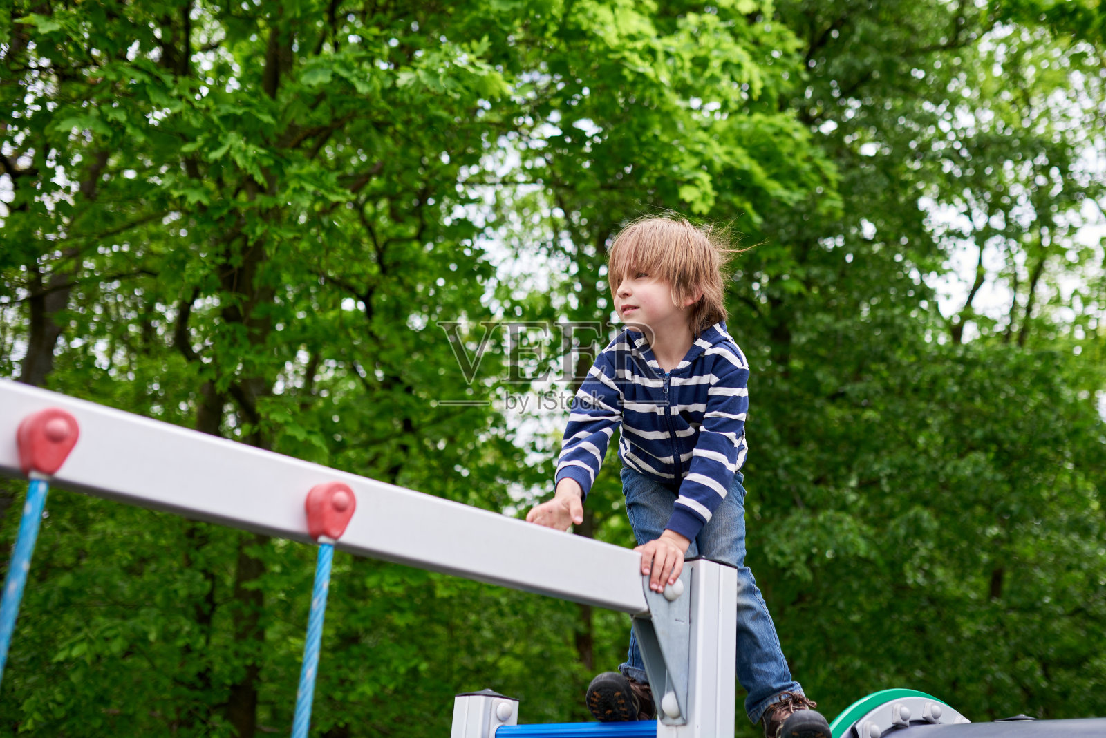 可爱的学龄前男孩在操场上攀爬的户外肖像照片摄影图片